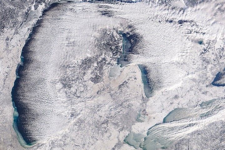 Satellite view of snow-covered land, ice, and dark water