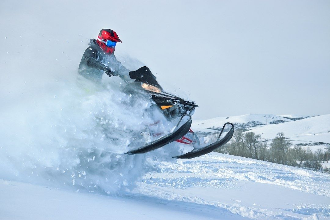 Snowmobile launching through deep powder on a snowy hillside